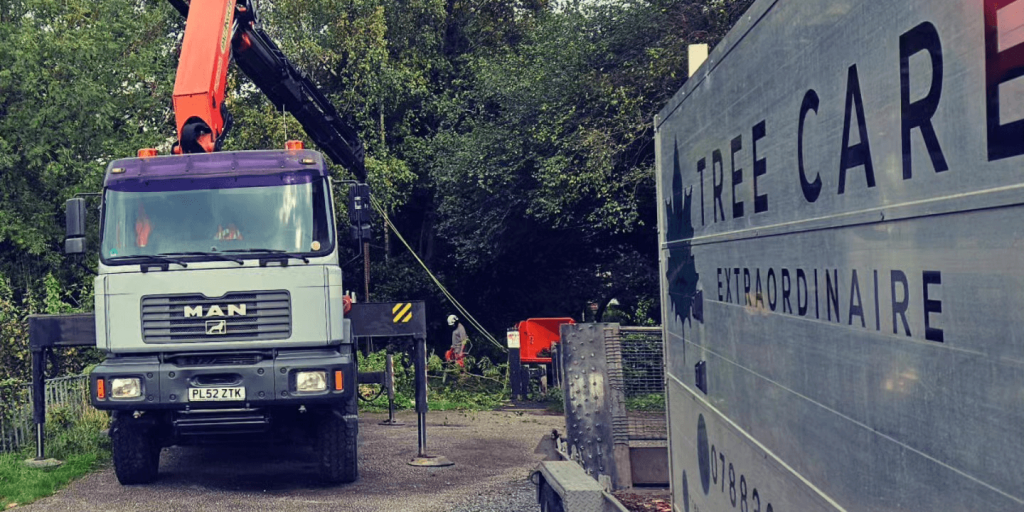 Loaded truck and trailer parked next to grab machine and lift.